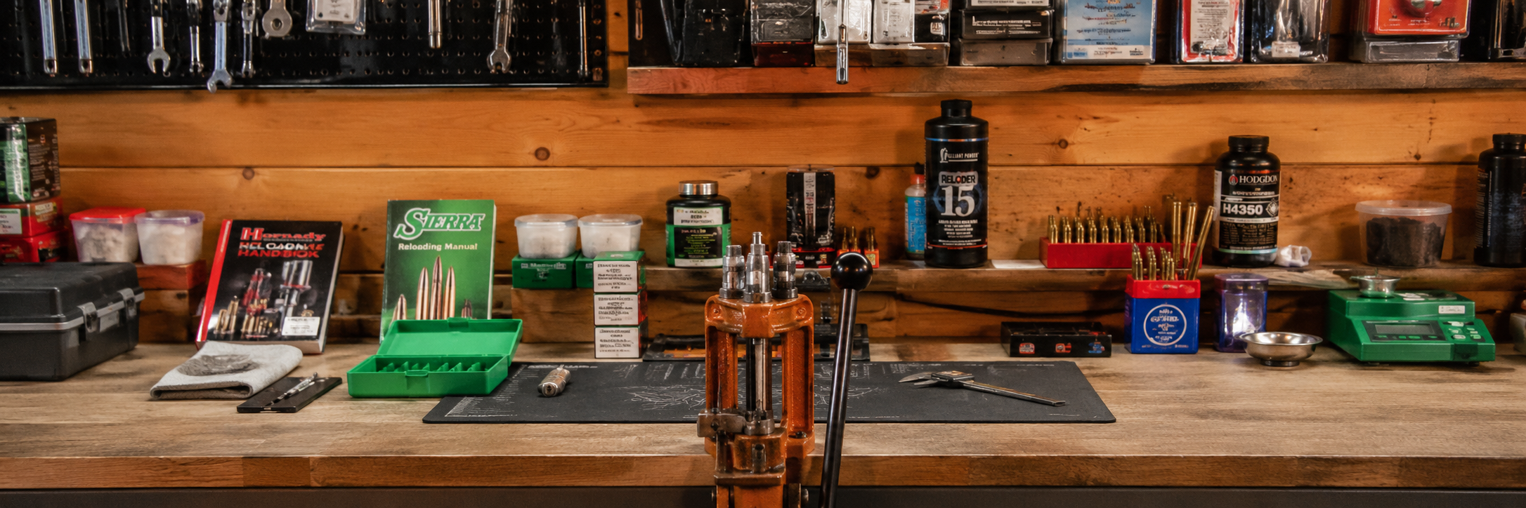 Organized precision workbench with a press, calipers, scale, and brass cases